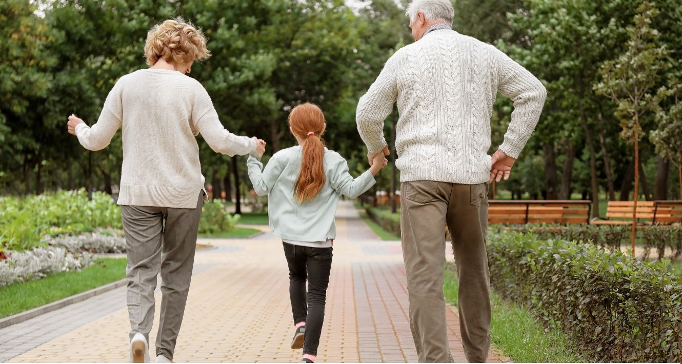 Grandparents walking with Granddaughter.